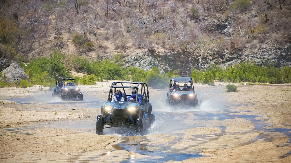 Off-road buggies traveling across riverbed in Los Cabos