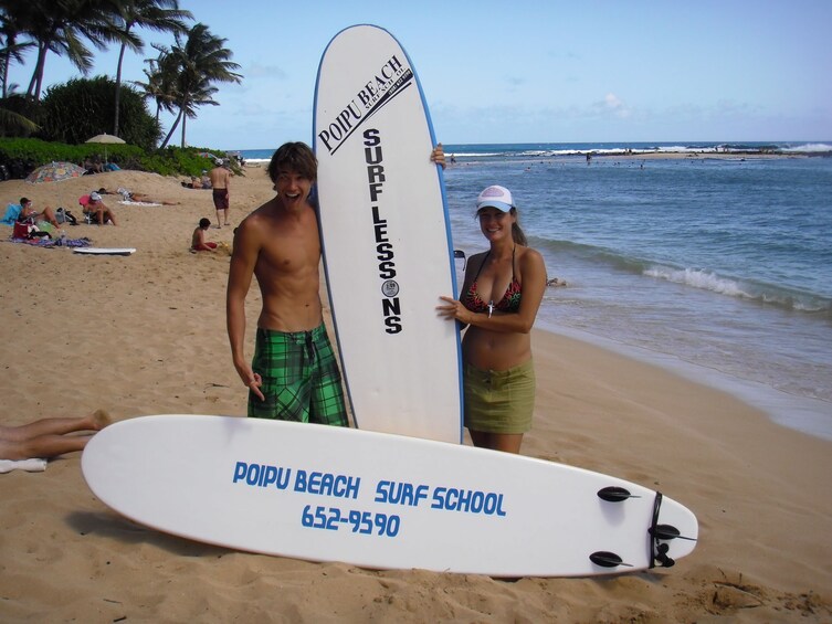 Couple on the beach with surfboards in Hawaii