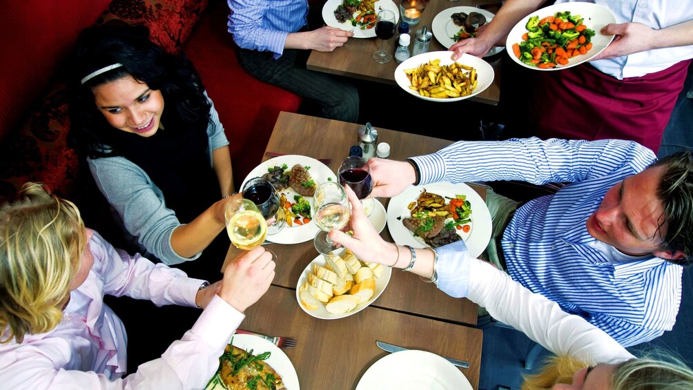 Show item 1 of 5. Group of people having meal at restaurant while on food tour in Galway