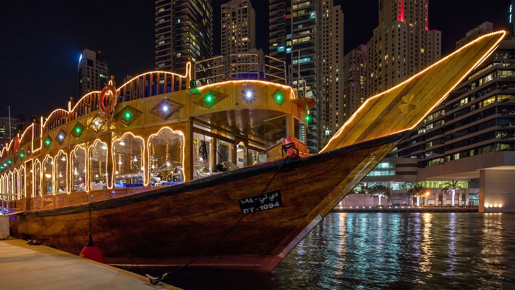 Cruise boat lit up at night in Dubai