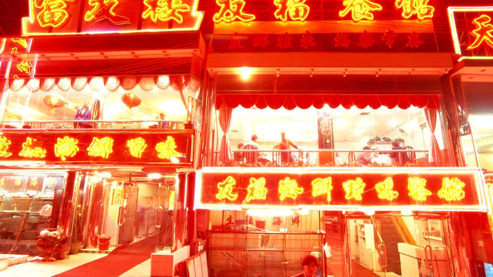 Show item 2 of 5. Restaurant lit up by neon signs in Shenzhen