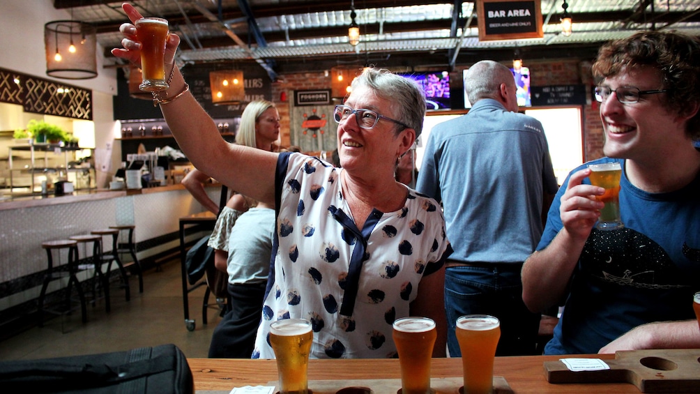 Woman looking at beer during pub walk in Sydney