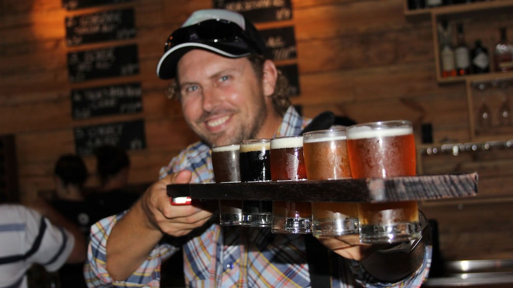 Man holding up flight of beer in Canberra