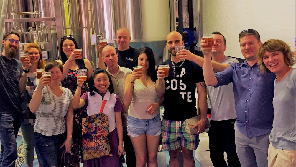 Tour group raising glasses of beer at the end of tour in brewery in Canberra