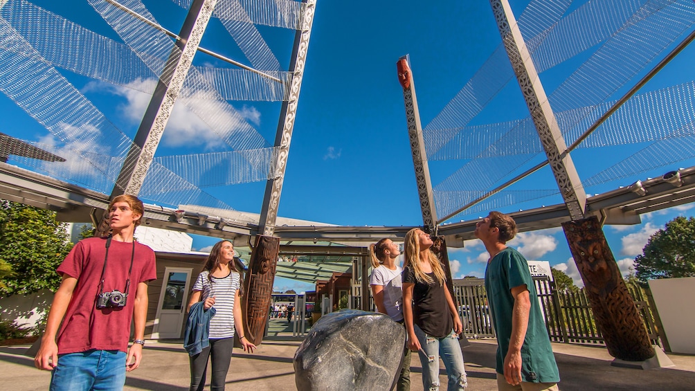 Tour group walk around art at Te Puia