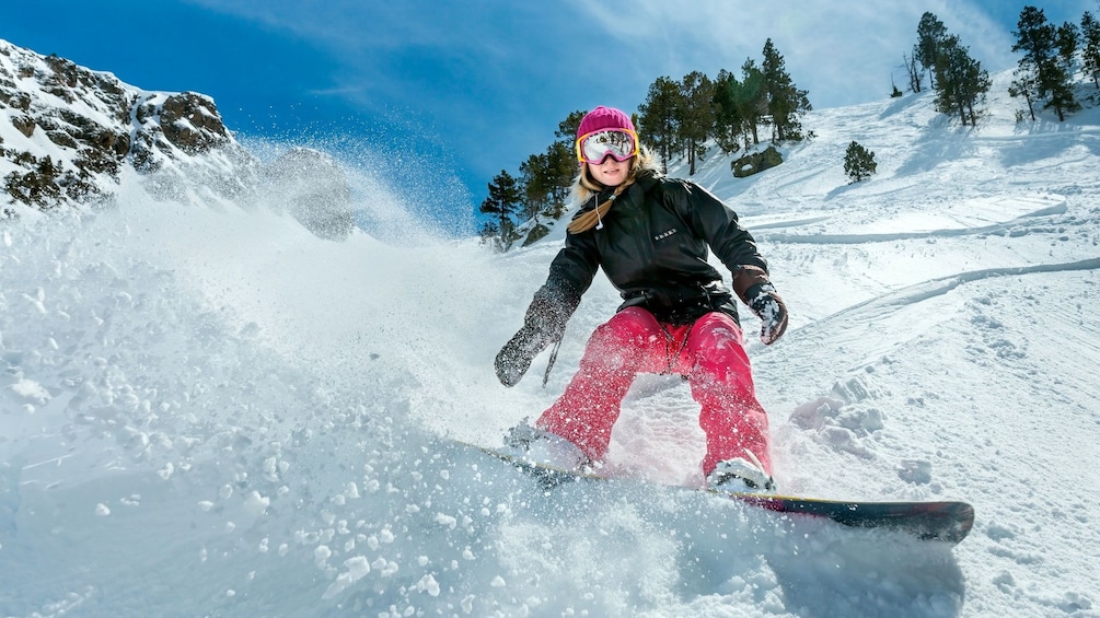 Woman snowboarding down slopes in Mammoth Lakes, California