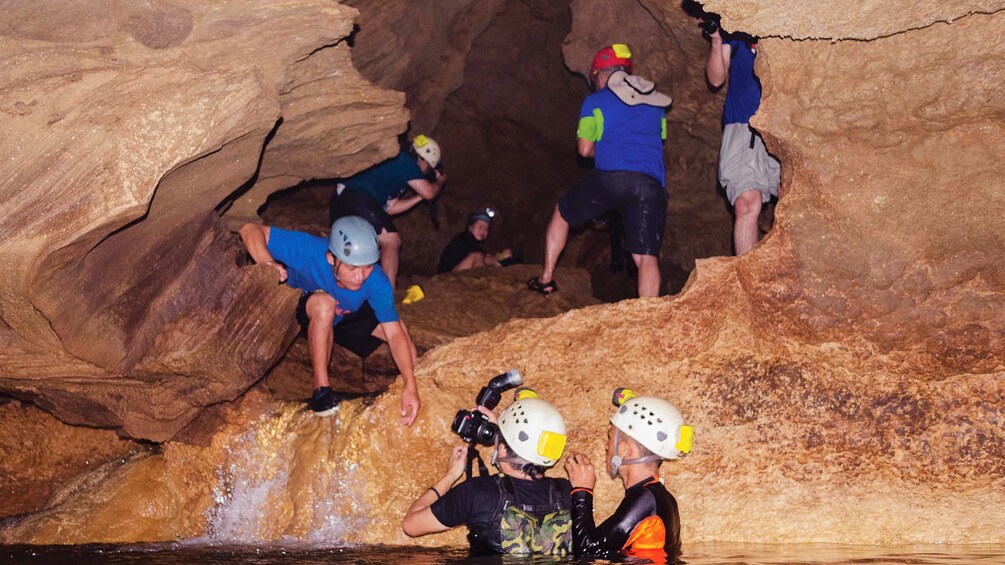 Group climbing into cave from water in Danao Adventure Park