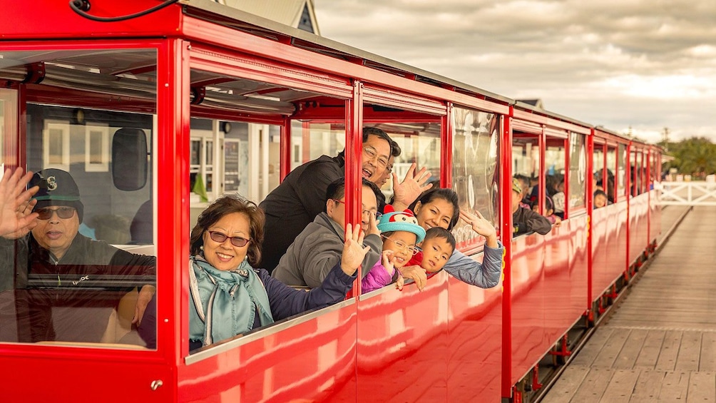 Family wave out window of train on Busselton Jetty