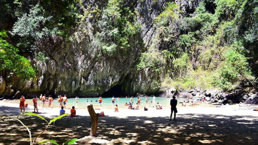 People enjoying natural pool near entrance of Emerald Cave in Koh Lanta