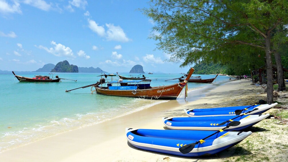 Boats moored at beach on island in Koh Lanta