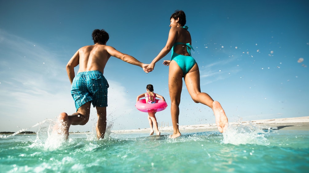 Family running in the ocean in Orlando