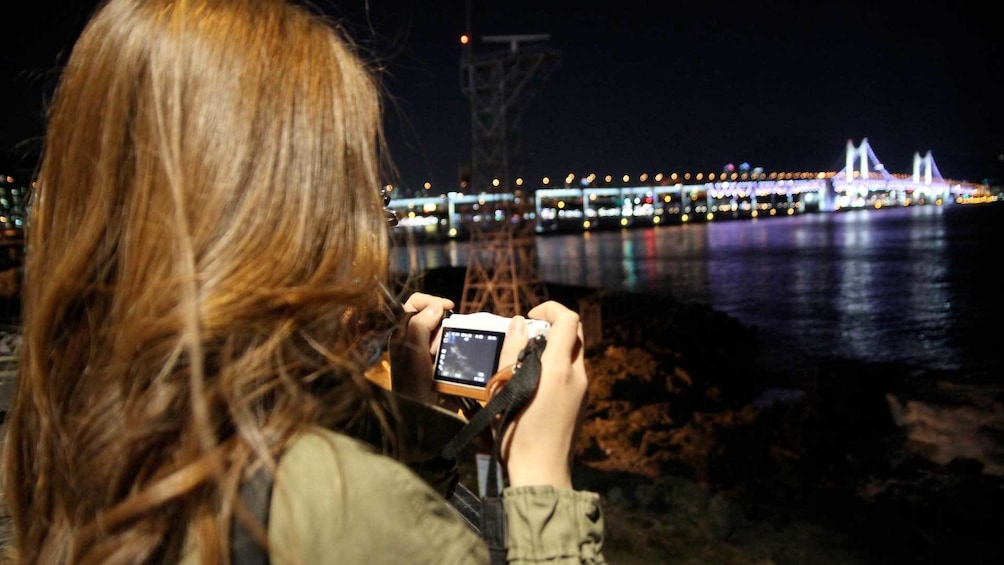Woman taking pictures of Busan City at Night