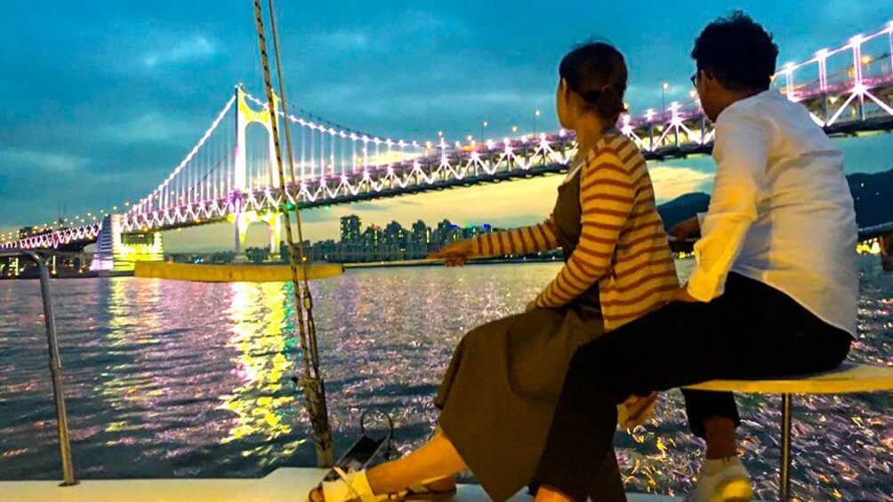 Two people on a yacht at night in Busan, South Korea at night