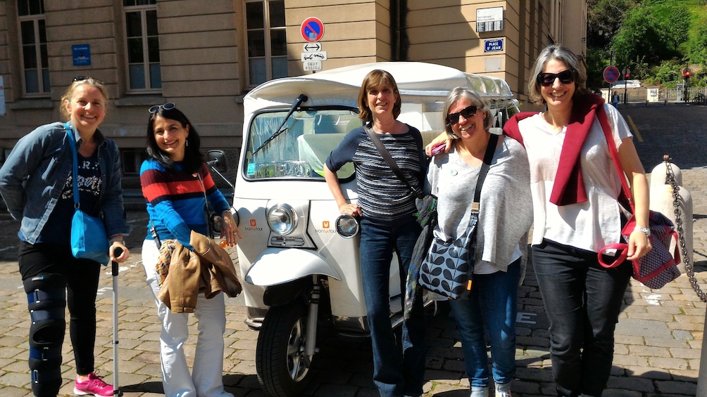 Show item 3 of 6. Tour group in front of Tuk vehicle in Lyon
