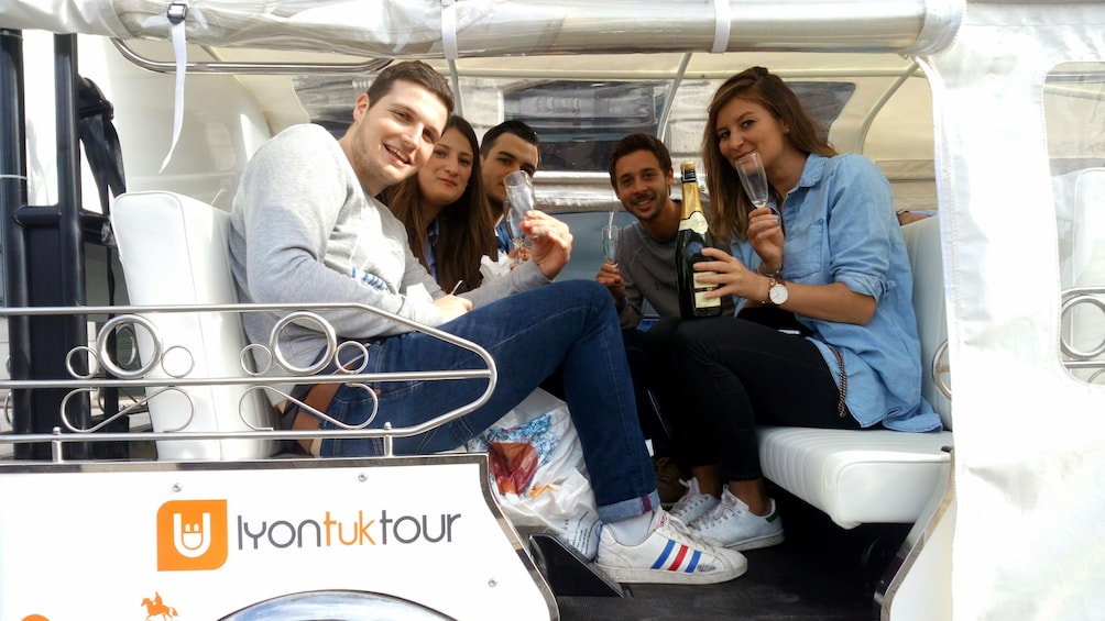Show item 2 of 6. Group with champagne on a Tuk vehicle in Lyon