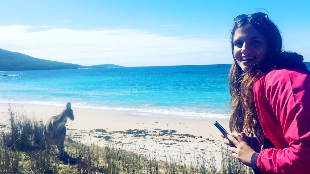 Woman poses next to a Kangaroo on the beach of Canberra