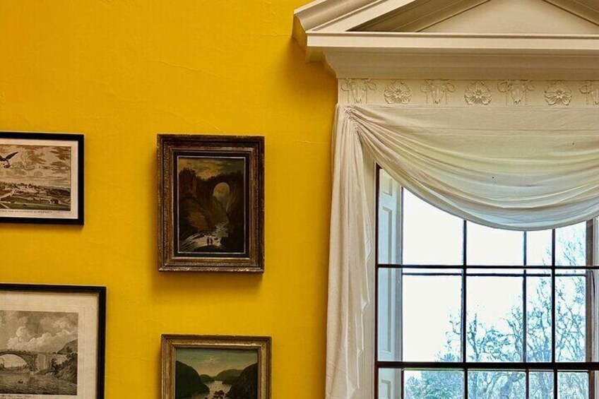 The chrome yellow walls of the dining room display a portrait of Natural Bridge that Thomas Jefferson once owned