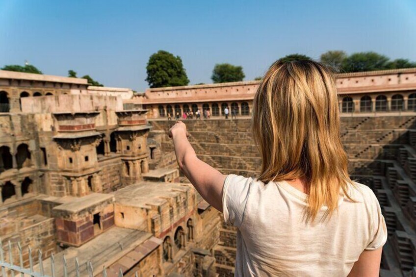 A Girl Traveler Pointing to Famous Stepwell Chand Baori.