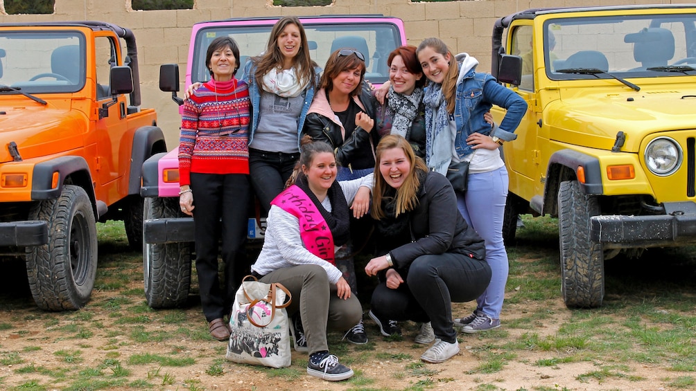 Show item 1 of 5. A group of people posing infront of colorful jeeps in Costa Blanca