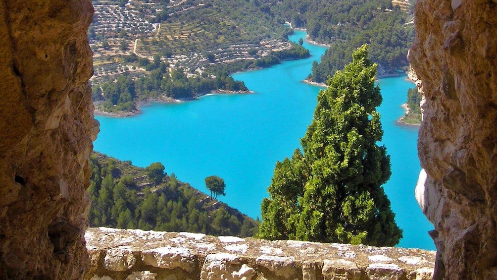 Show item 2 of 5. View of bright cerulean waters from atop a hill in Guadalest