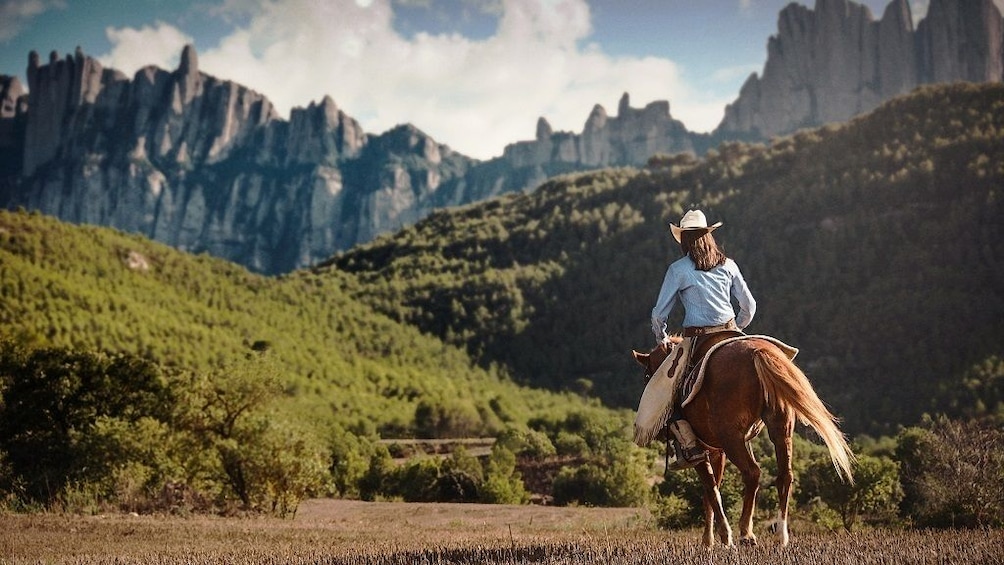 Woman on horseback near mountains in Catalonia