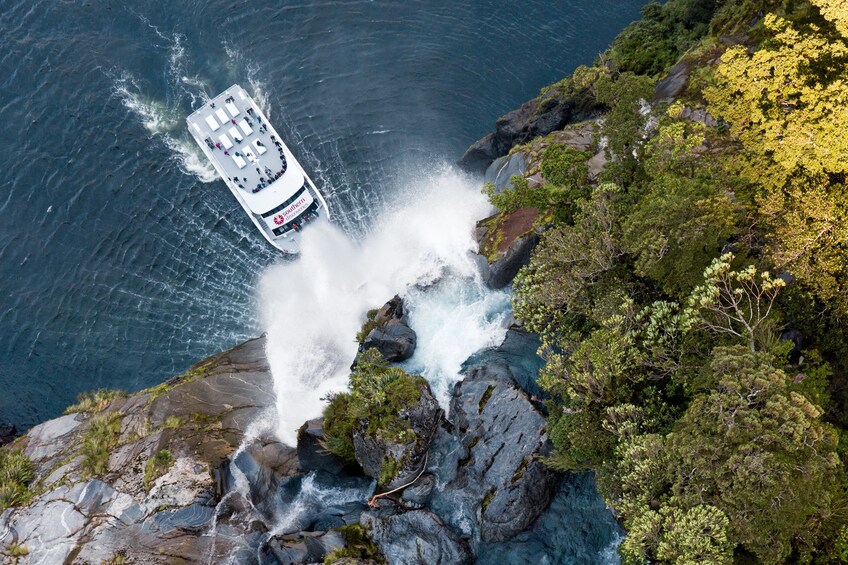 Boat at the bottom of a waterfall in New Zealand