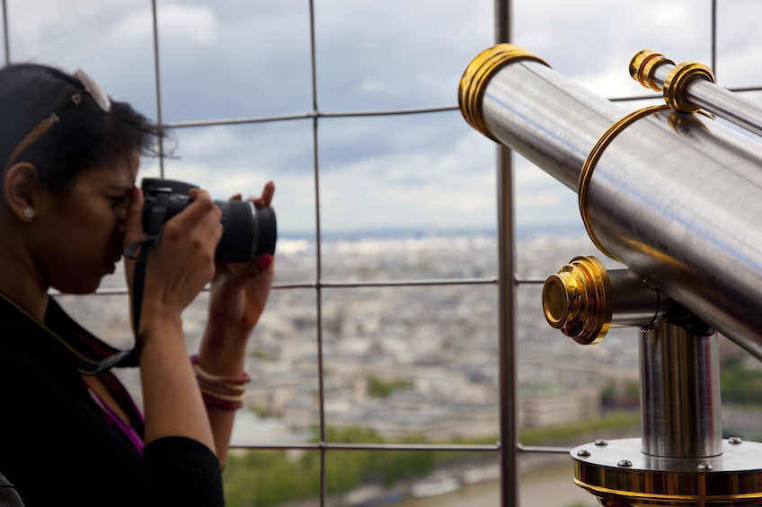 Woman taking a photo from the Eiffel Tower 