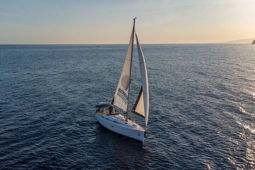 Sailing at sunset along the cliffs of Maro-Compartida