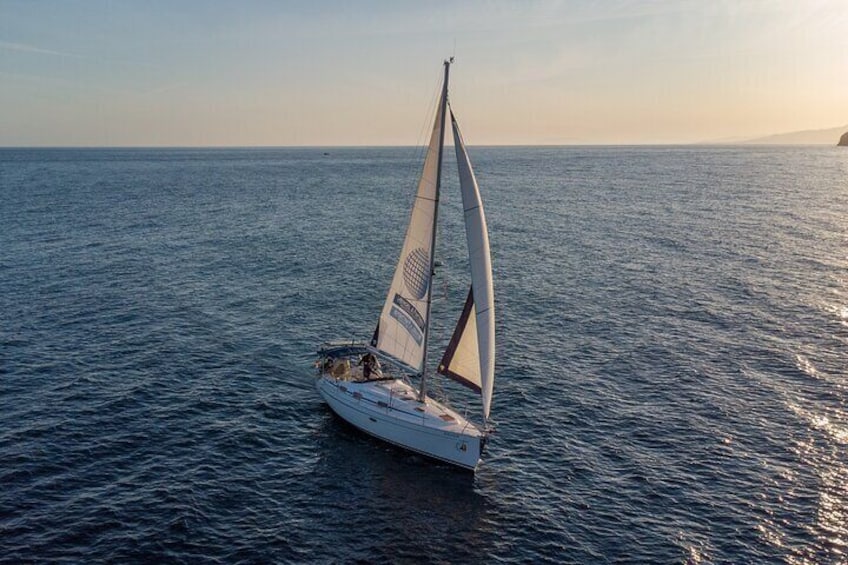 Sailing at sunset along the cliffs of Maro-Compartida