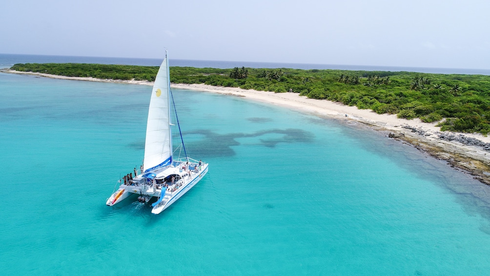 Aerial shot of catamaran anchored in clear blue water