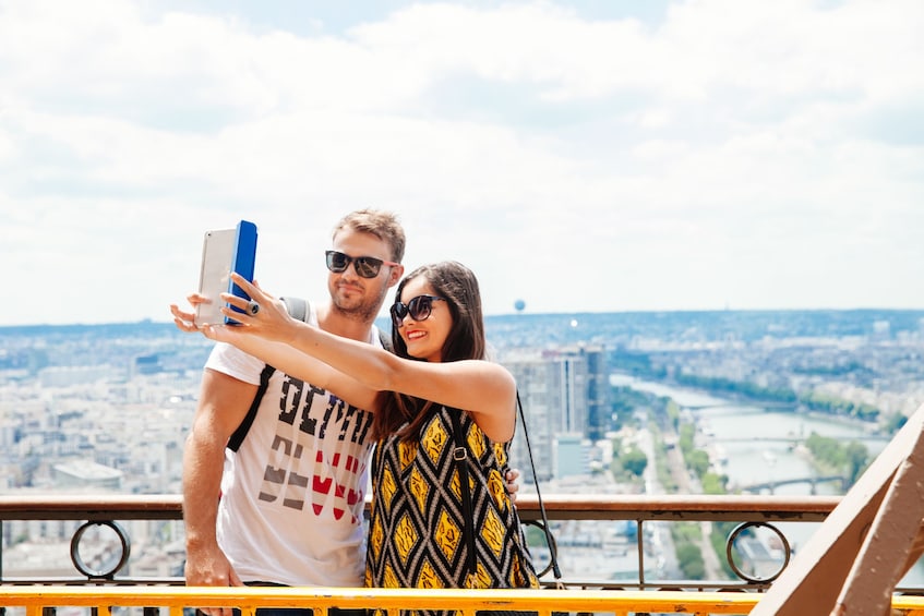 Couple taking a selfie on the Eiffel Tower in Paris