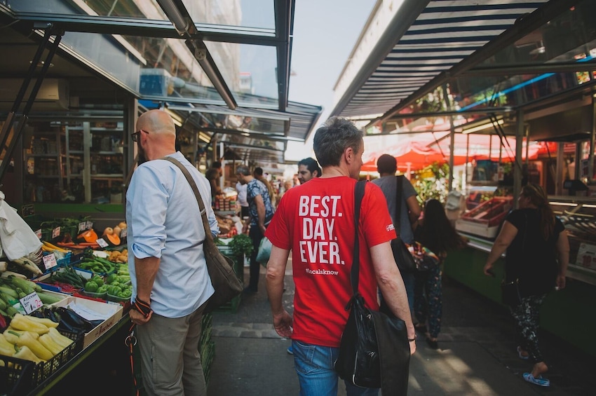 Show item 1 of 10. Tour guide walking through market in Vienna
