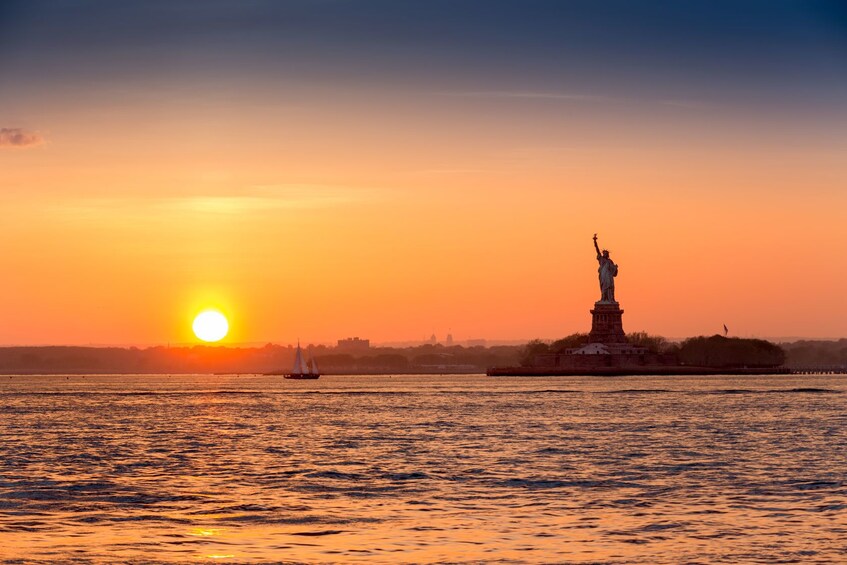 Distant view of the Statue of Liberty at sunset