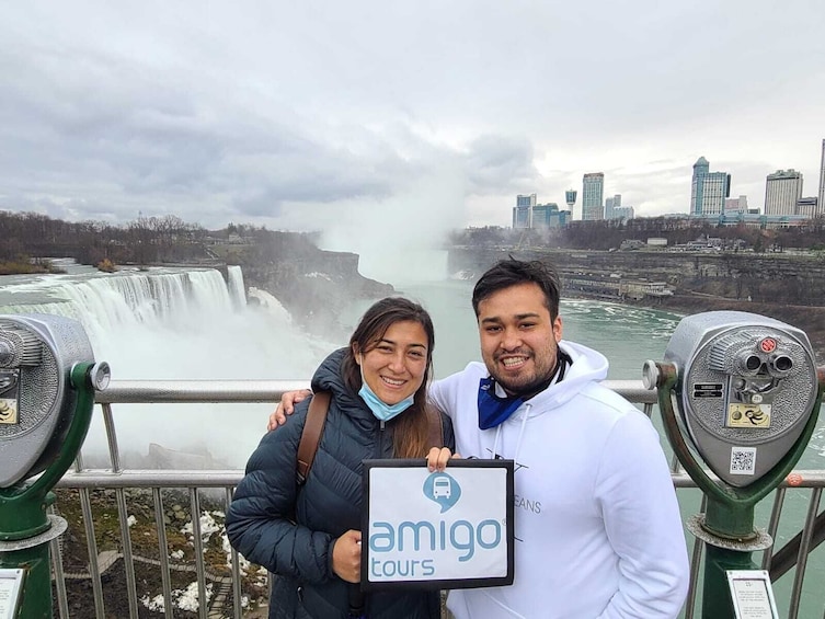 Couple holding sign in front of Niagara Falls