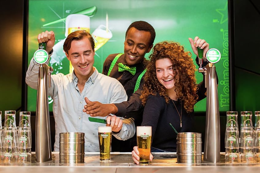 Group filling beer glasses on the Heineken® Experience tour in Amsterdam