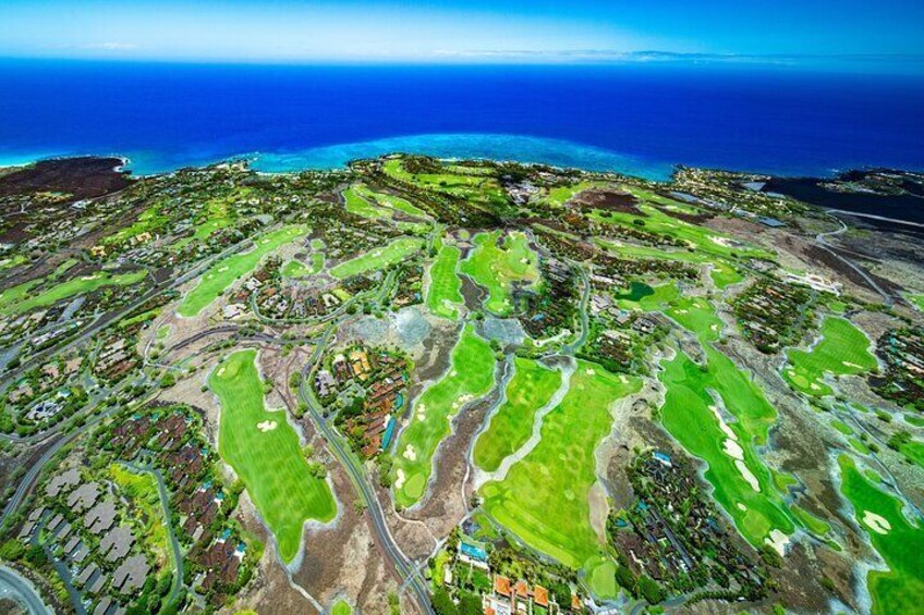 Glide over famous courses encircled by the rugged flow of Hualālai’s volcano