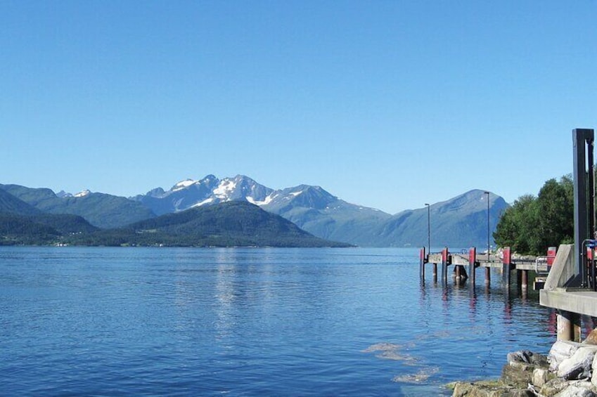 From Sykkylven we cross the fjord Storfjorden. 15 minutes by car ferry and splendid views.