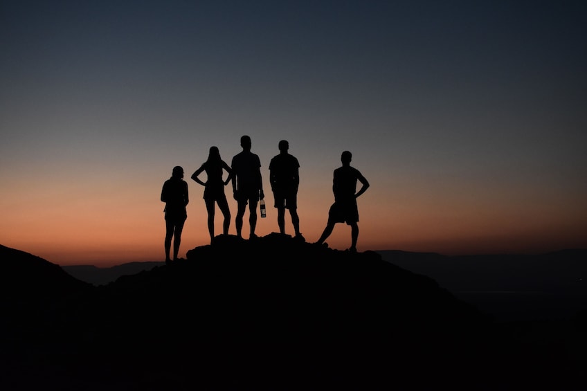 Silhouette of hikers with sunset in the background in Israel