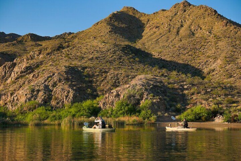 Lush green mountains set as a backdrop for paddlers.