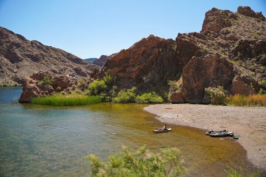 A kayaker rests on a secluded beach.