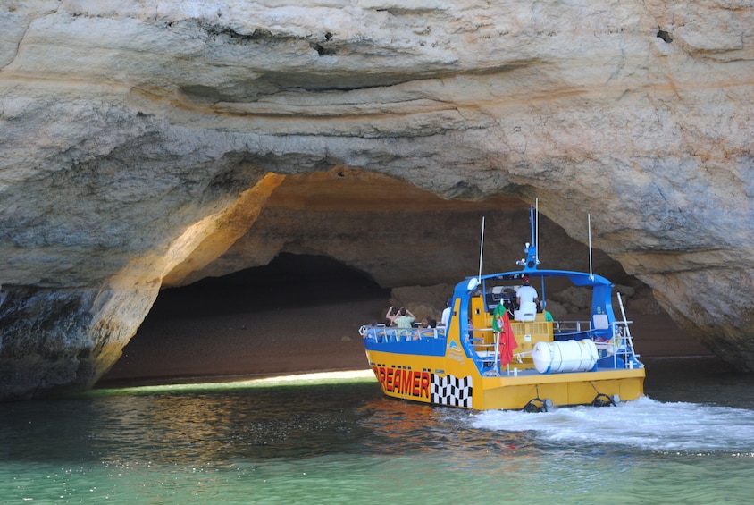 Boat entering a sea cave off the coast of Algarve