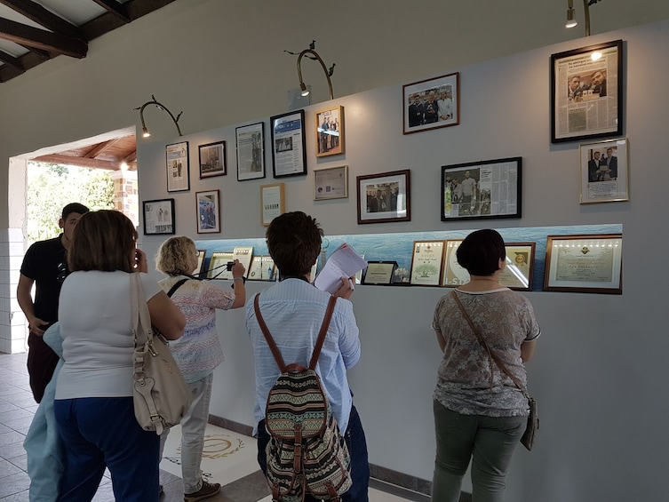 Show item 4 of 4. Tour group looking at pictures on a wall in Corfu