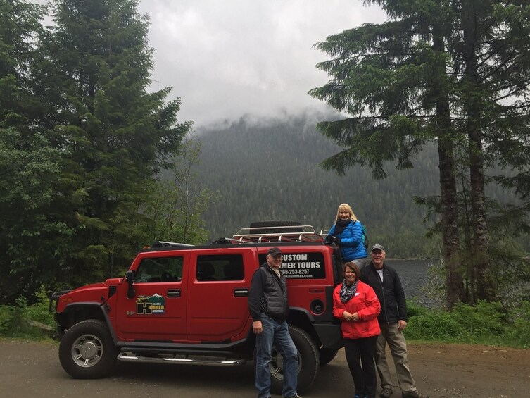 Family on a private tour of Alaska via a red Hummer car 
