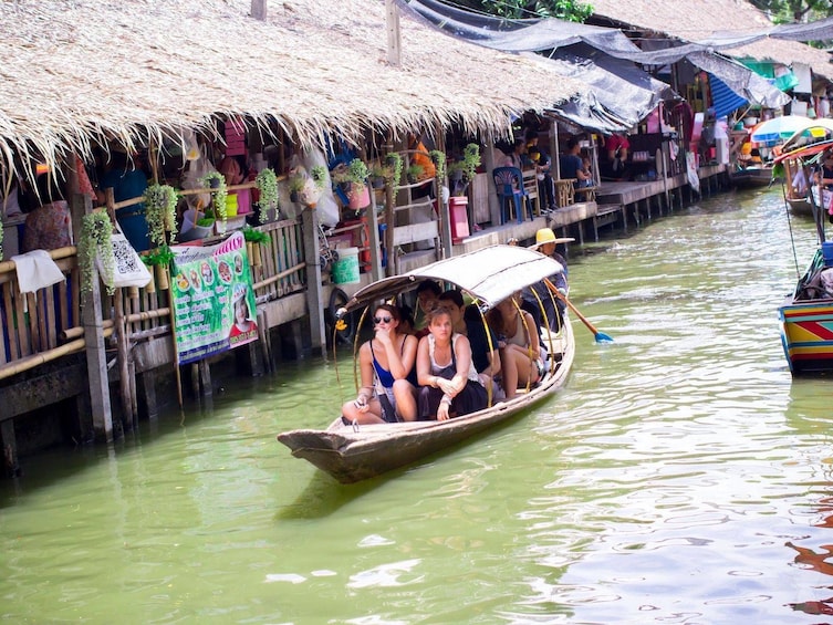 Guests taking a long-tail boat ride on the Damnoen Saduak Floating Market tour 