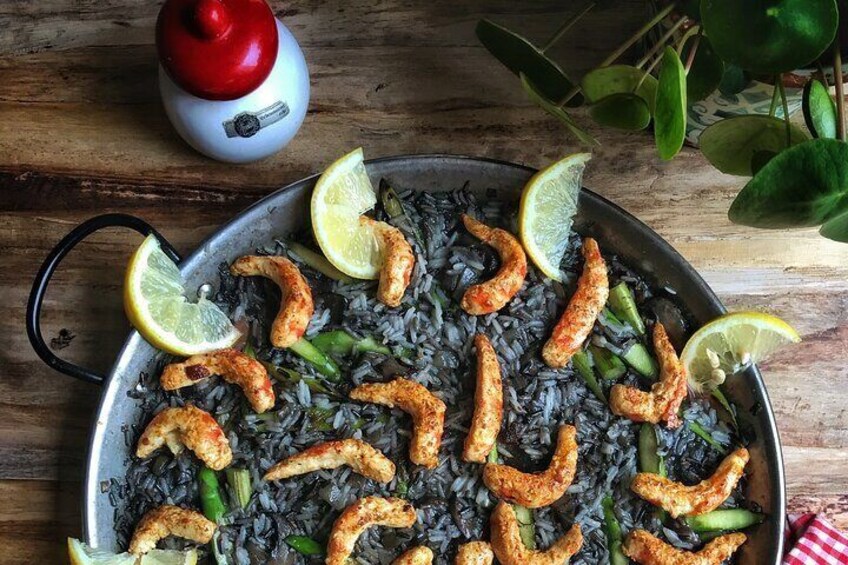 Black rice paella with vegan shrimp and seasonal mushrooms.