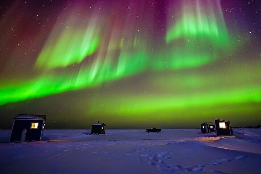 Aurora above ice fishing huts