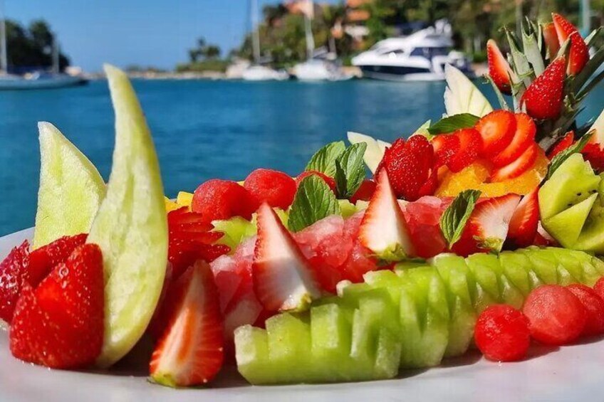 Enjoy a beautifully presented fruit platter with a vibrant mix of fresh seasonal fruits—perfectly paired with stunning views of the Riviera Maya