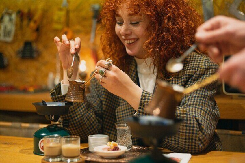 Smiling participant enjoying the process of Turkish coffee making during a workshop in Istanbul.