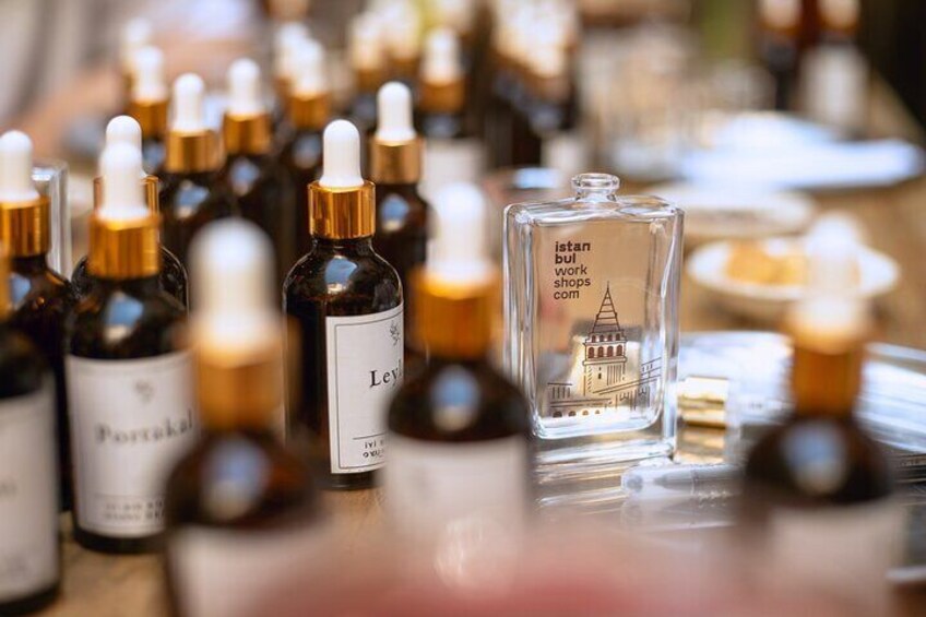 A wide variety of fragrance bottles and tools laid out for participants at the perfume workshop in Istanbul