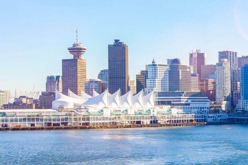 Cityscape View: Enjoy a breathtaking view of Canada Place and downtown Vancouver from the lush vantage point of Stanley Park. This iconic perspective highlights the vibrant cityscape against the seren